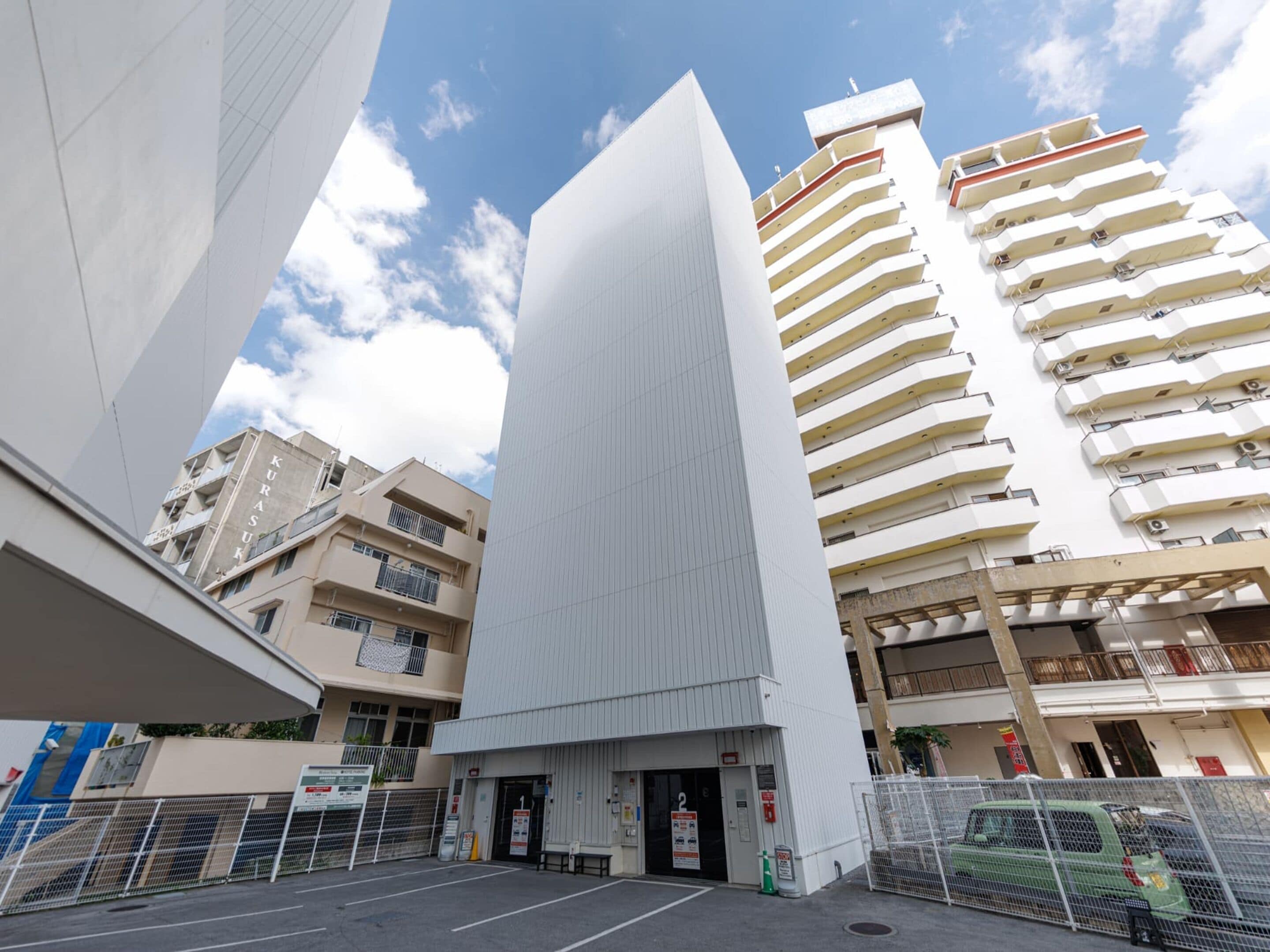 A modern building with a parking lot in front.