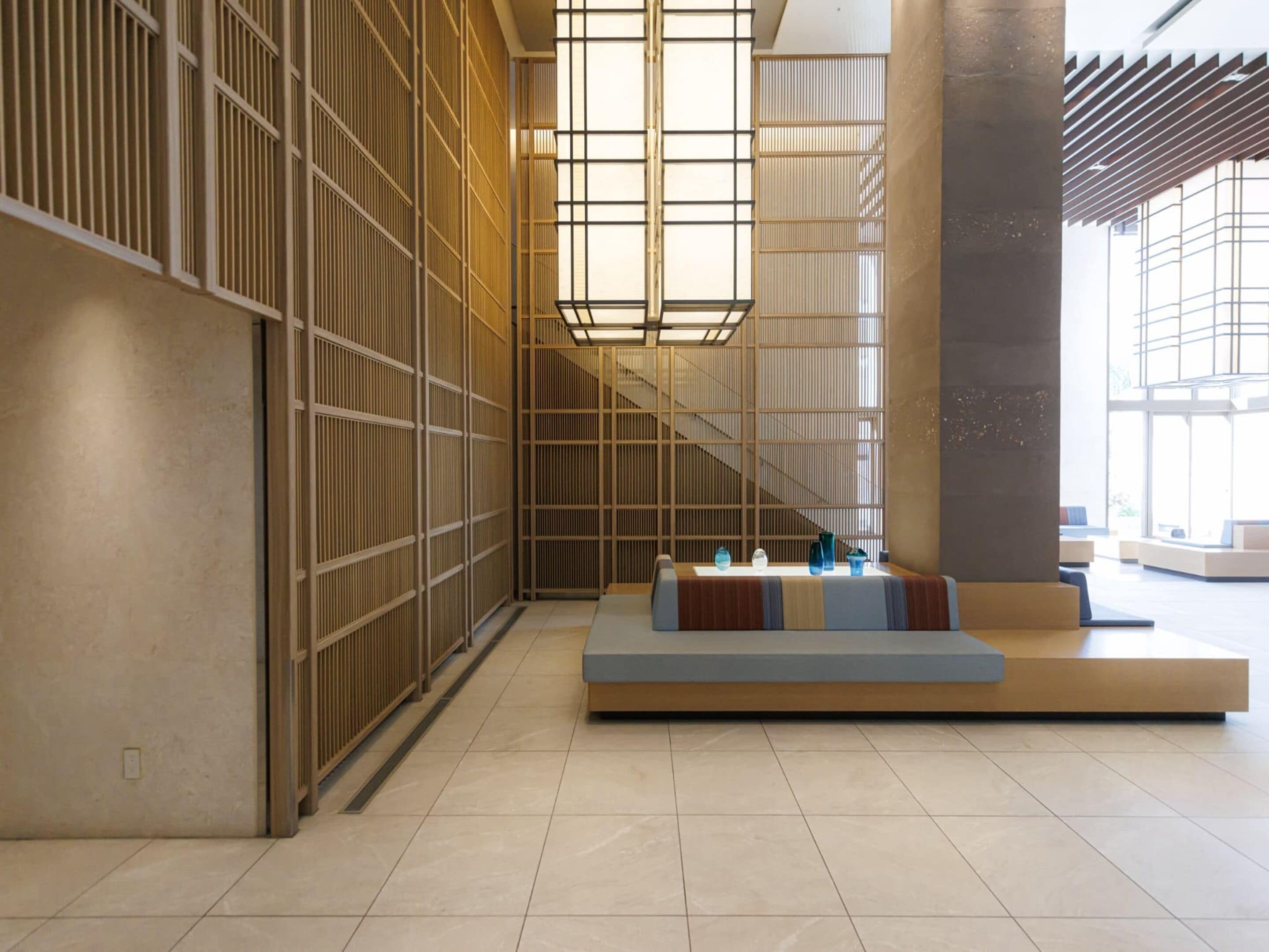 A modern interior with a seating area, a staircase, and a large window.