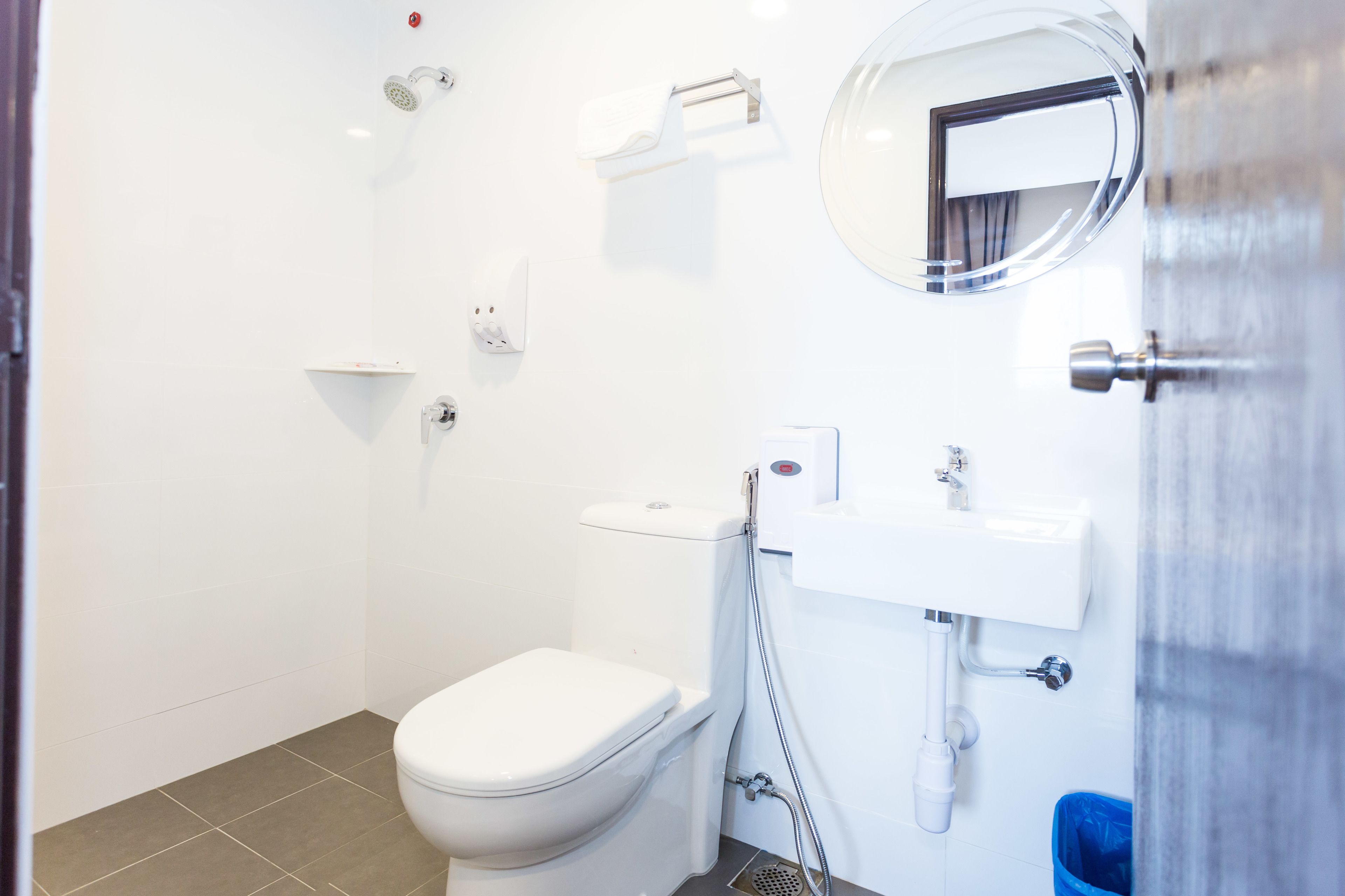 A modern bathroom with a toilet, sink, and shower.