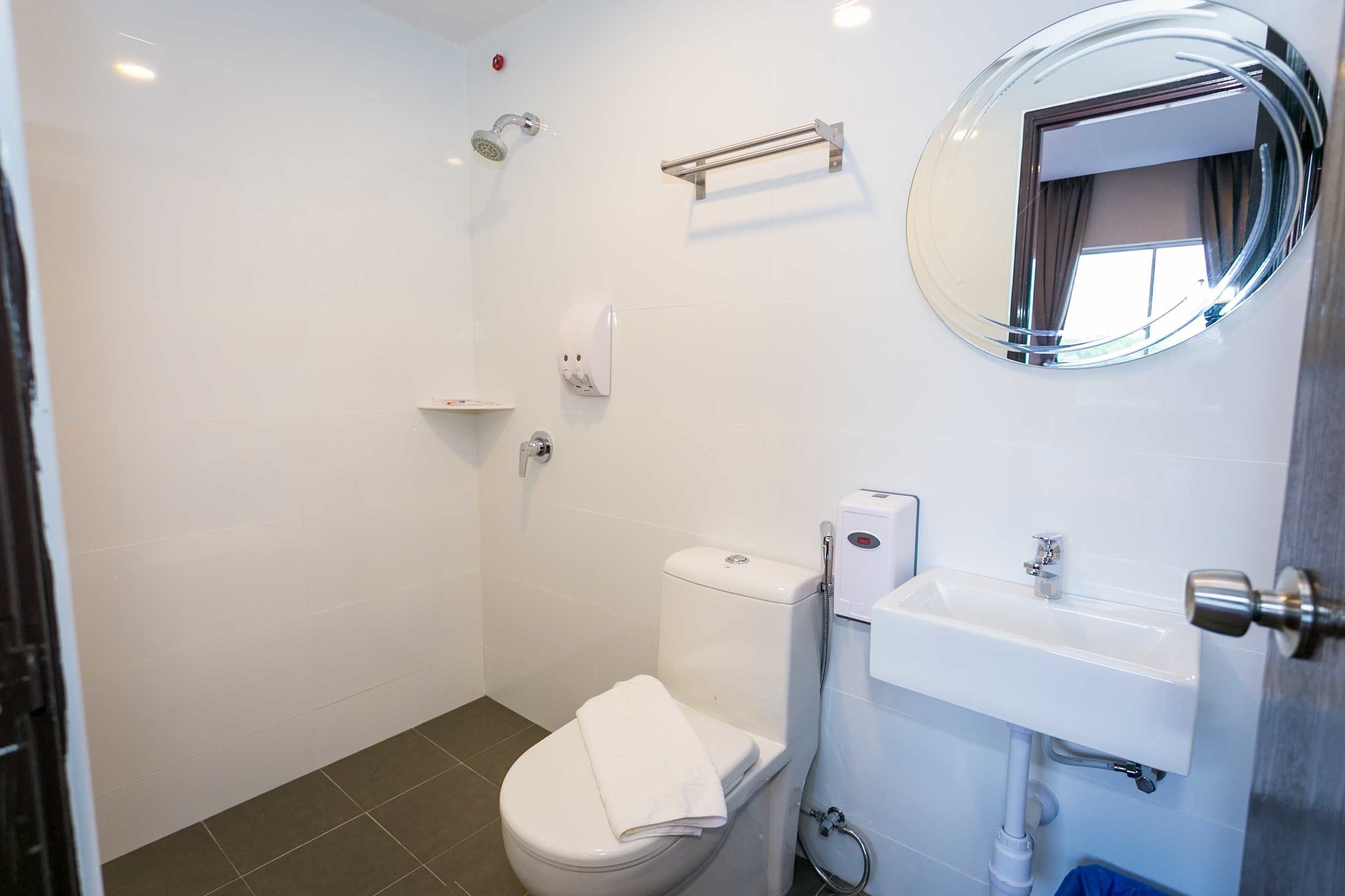 Un baño moderno con inodoro, lavamanos y ducha.
