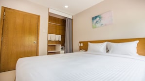 A hotel room with a large bed, wooden wardrobe, and a bathroom visible through an open door. - GK Garden Apartment (Ho Chi Minh City)