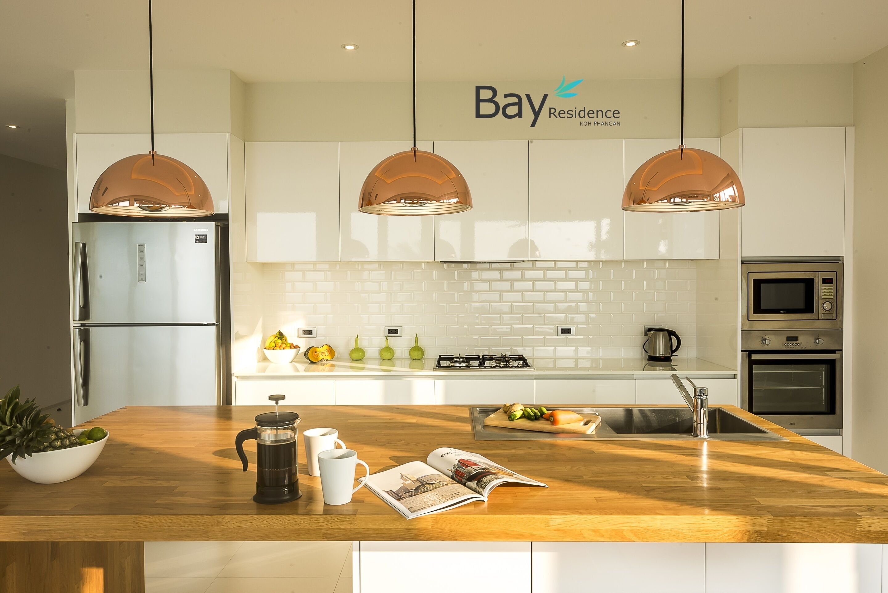 Una cocina moderna con armarios blancos, electrodomésticos de acero inoxidable y una isla de madera.