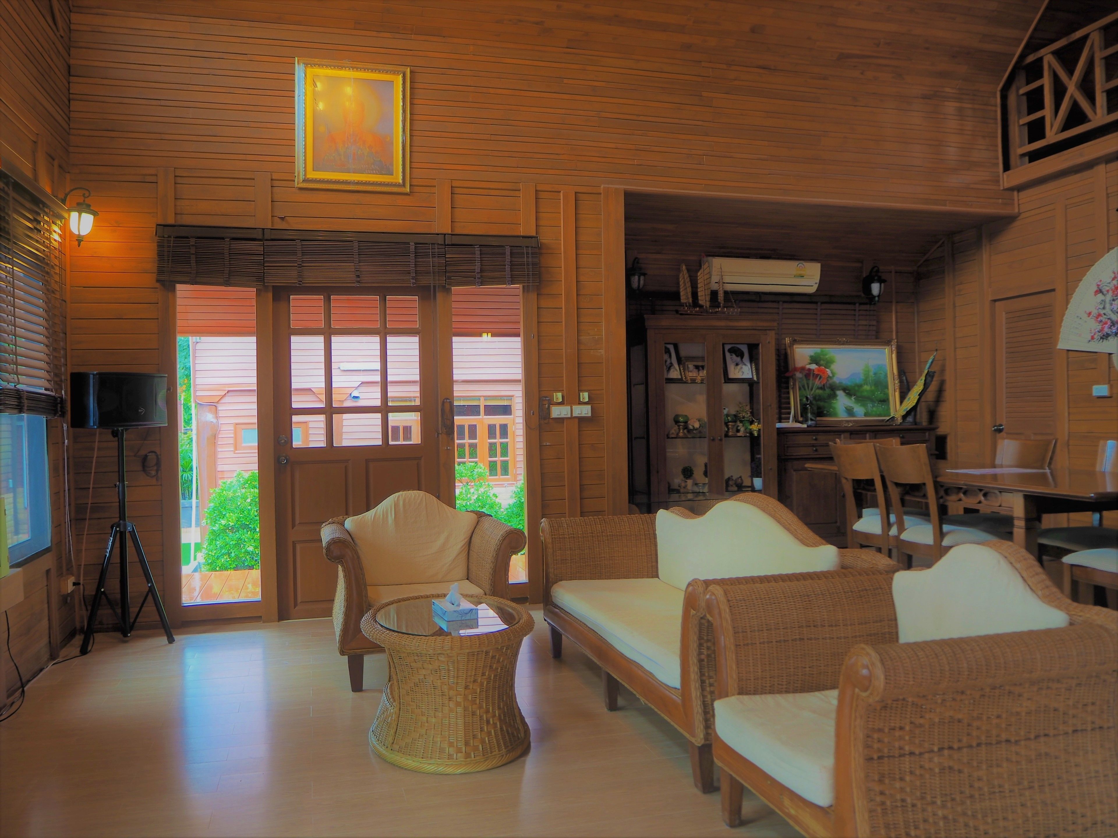 A cozy room with wicker furniture, a glass coffee table, and a television.