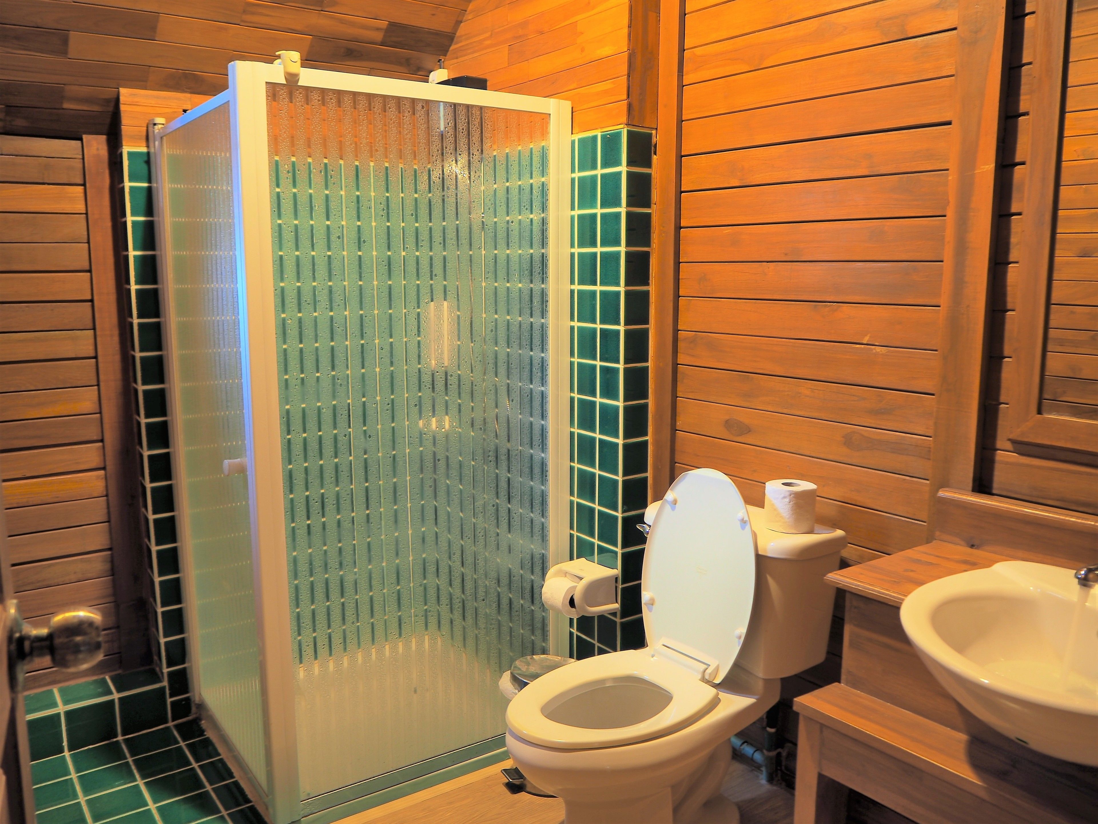 Un baño con cabina de ducha, inodoro y lavamanos.