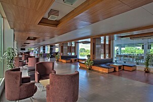 Um hall espaçoso com assentos modernos e amplas janelas com vista para o exterior.