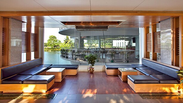 A modern lobby with seating areas, a central plant, and a view of the outdoor area. - BRAC-CDM Savar (Savar)