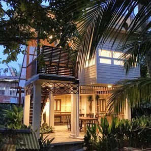 A two-story house with a balcony, a staircase, and a garden area with plants. - Baan Suan Amphawa (Amphawa)