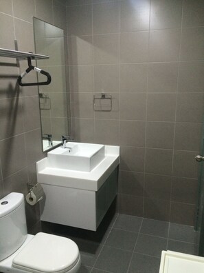 A modern bathroom with a white sink, mirror, and toilet. - Summer Suites Express by Subhome - Hostel (Kuala Lumpur)