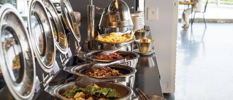 A buffet setup with various dishes and utensils.