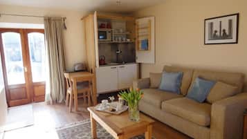 Una sala de estar con un sofá, una mesa de centro y un comedor con una mesa y sillas.