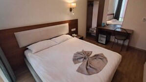 A hotel room with a bed, a desk, a chair, a mirror, and a TV. - Reikartz 2017 (Ankara)