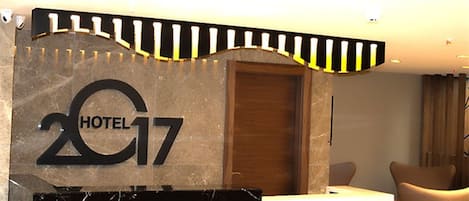 A reception desk with a marble top and a sign reading "HOTEL 17".