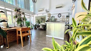 Una cocina amplia con suelo de madera, una isla central y diversas plantas.