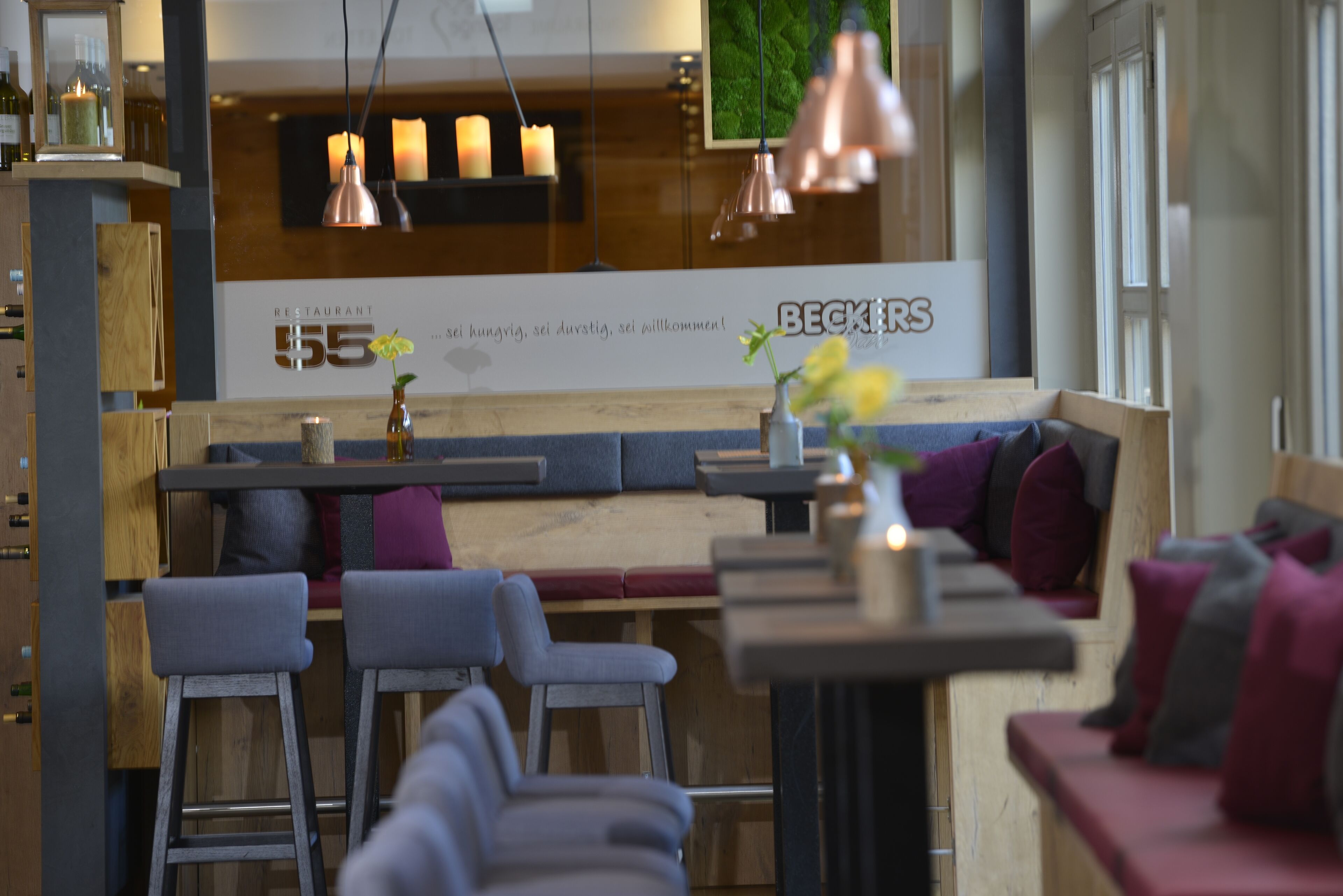 A modern restaurant interior with wooden furniture, a bar area, and a seating section.