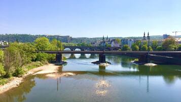 A bridge over a calm river with a cityscape in the background.