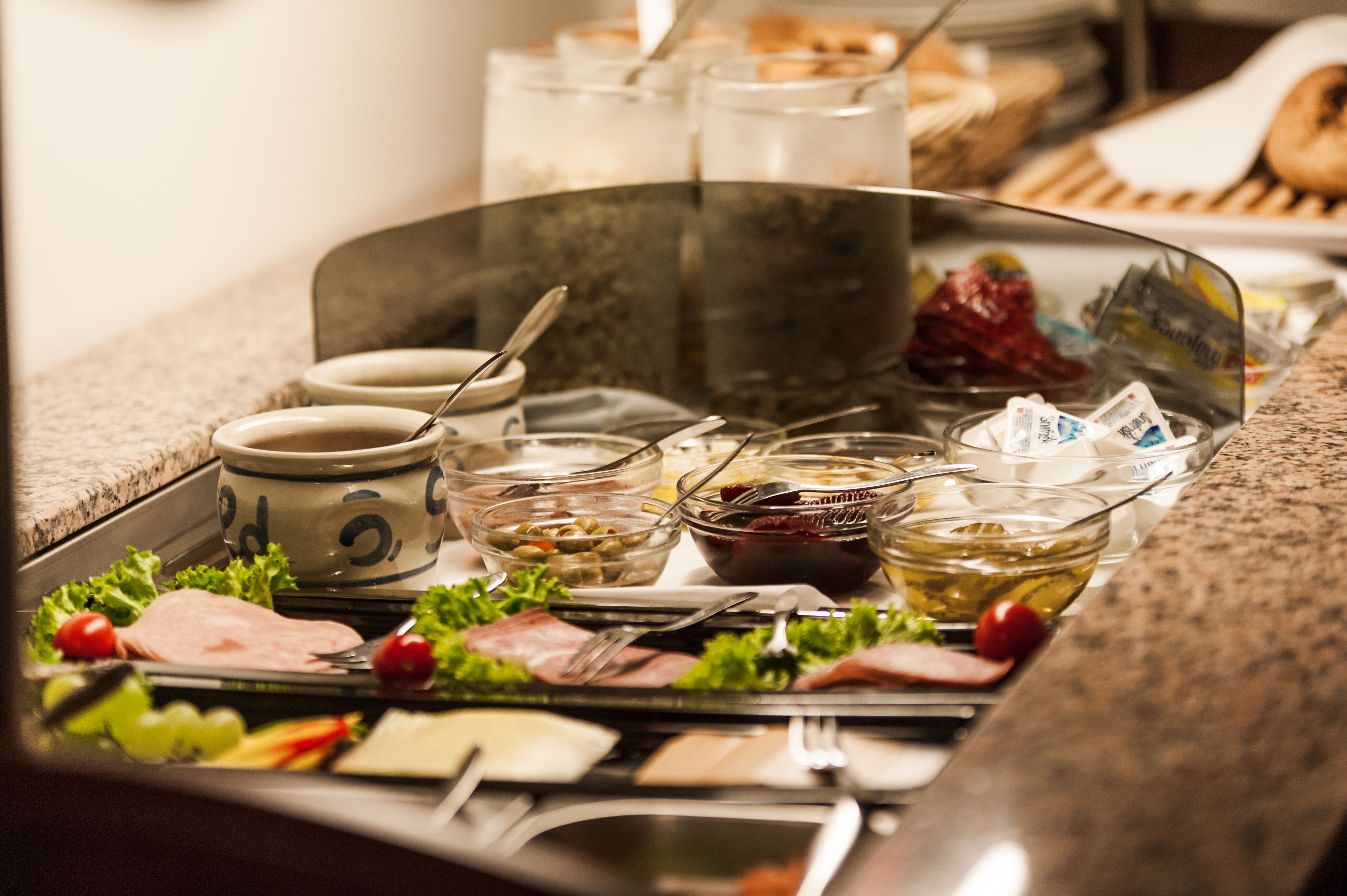 A buffet with various food items and utensils.