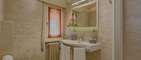 A bathroom with a toilet, sink, and shower.