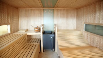 Una stanza sauna con panche in legno e un lettino da massaggio.