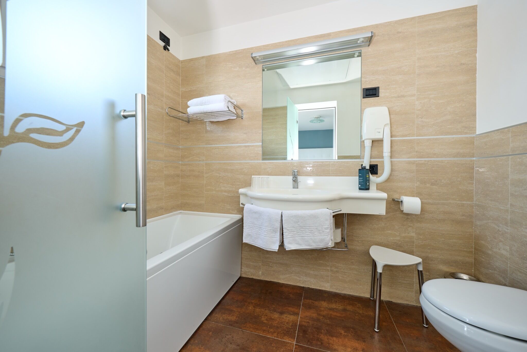 Un baño moderno con bañera, lavamanos e inodoro.