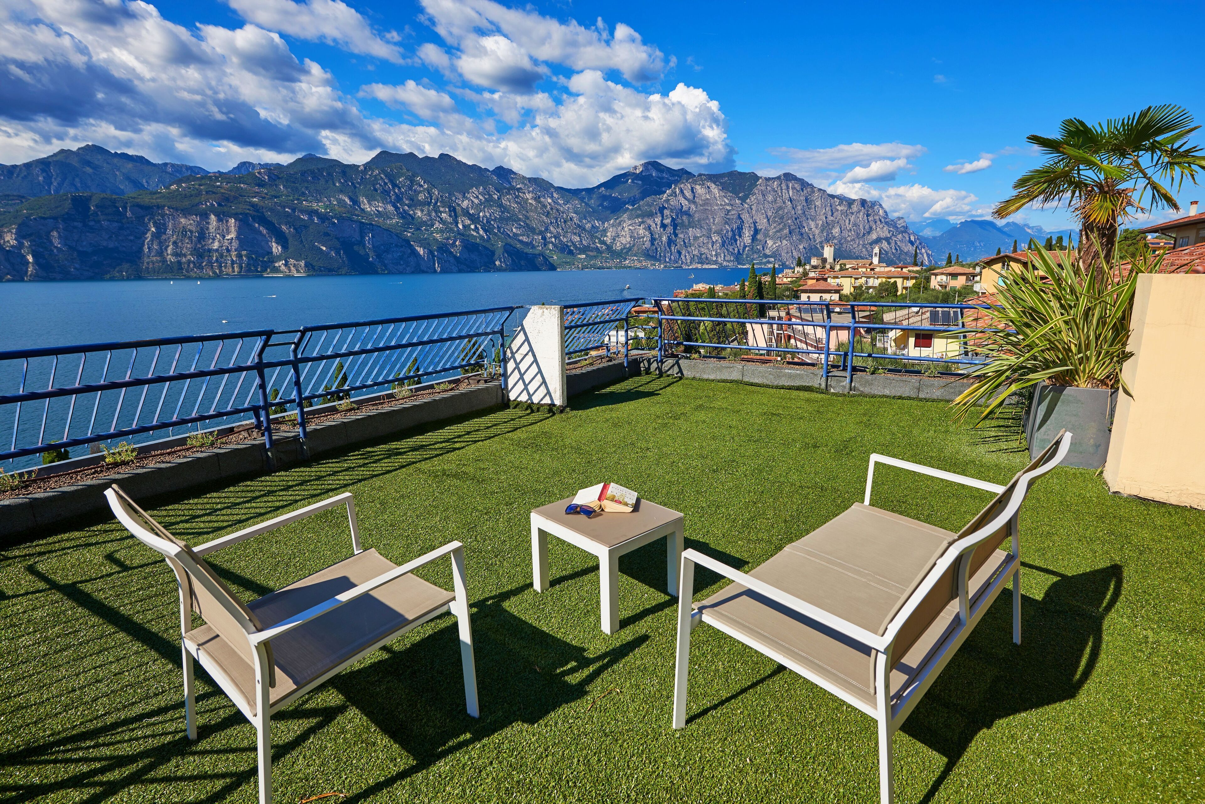 An outdoor seating area with a view of a lake and mountains.