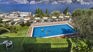 A swimming pool with a view of mountains and the sea. - Hotel Capri (Malcesine)