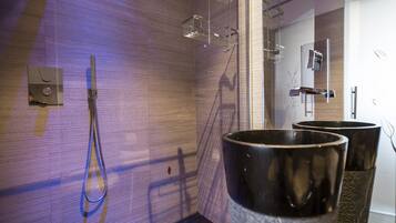 A modern bathroom with a shower, a toilet, and a bidet.