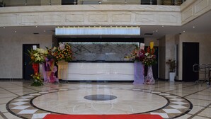 A hotel reception area with a marble floor, a red welcome mat, and floral arrangements. - InnB Park Hotel (Kuala Lumpur)