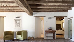 A room with wooden beams, a bed, a desk, and two armchairs. - La Rectoria De Sant Miquel De Pineda (Sant Feliu de Pallerols)