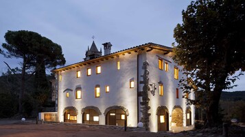 Un edificio histórico con múltiples arcos y una torre con aguja.