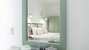 A bedroom with a bed, bedside table, and a mirror reflecting the room. - Paydos Pansiyon (Kas)