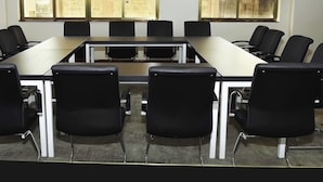A conference room with a long table and black chairs. - Lagos Hotel (Nairobi)