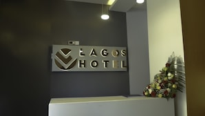 A reception desk with a sign reading "Lagos Hotel" and a floral arrangement. - Lagos Hotel (Nairobi)