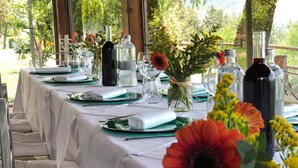 A long table set outdoors with white tablecloths, green plates, and clear glassware. - Borgo La Capraia (Castelfranco Piandisco)