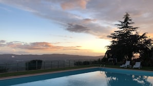 A swimming pool with a view of mountains and a sunset. - Borgo La Capraia (Castelfranco Piandisco)