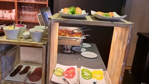 Una mesa de buffet con diversos alimentos y utensilios.