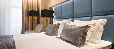 A neatly made bed with a blue headboard and white bedding.