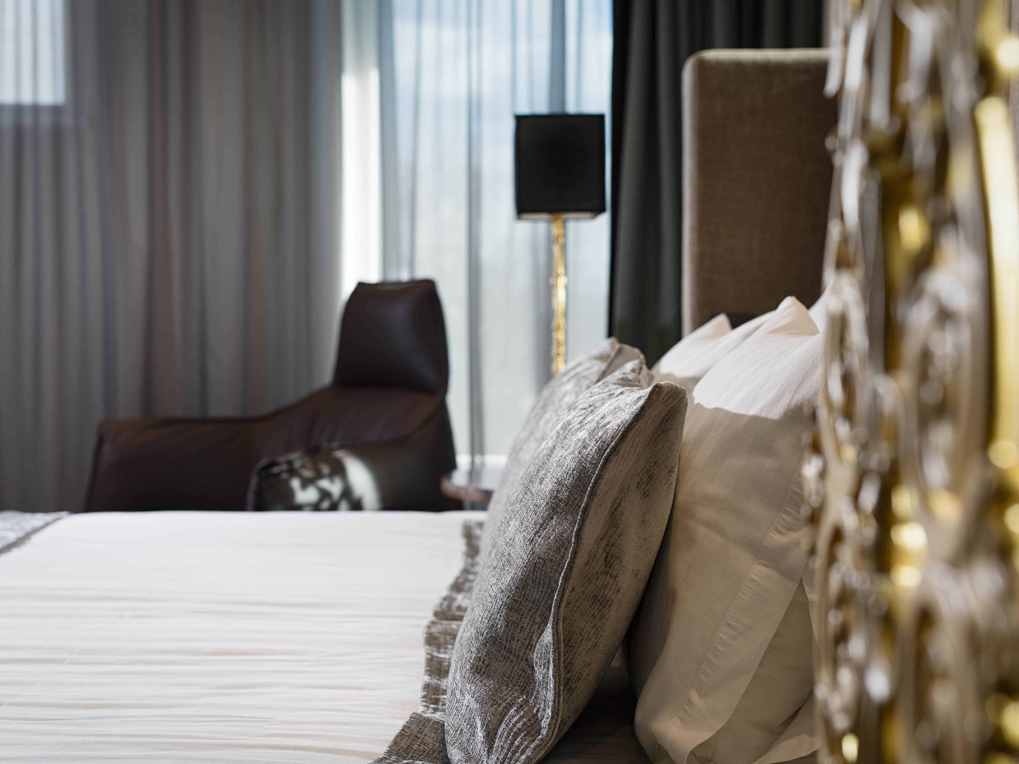 Ein Hotelzimmer mit einem Bett, einem Sessel und einer Lampe.