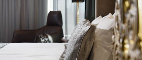 Una habitación de hotel con una cama, una silla y una lámpara.