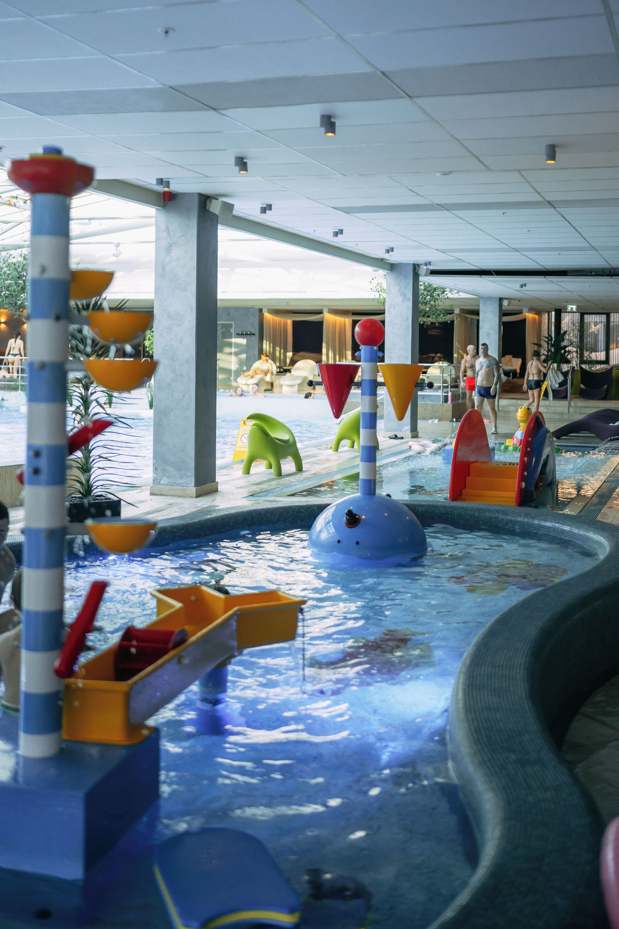 An indoor water play area with slides and play structures.