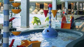 An indoor water play area with slides and play structures.