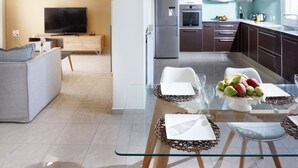 A modern kitchen with a dining area, a television, and a refrigerator. - Dream Villa (Chania)