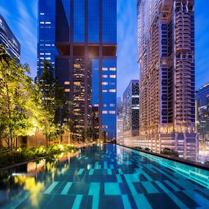 A modern urban hotel with a reflective pool, high-rise buildings, and lush greenery. - Dao by Dorsett AMTD Singapore (Singapore)