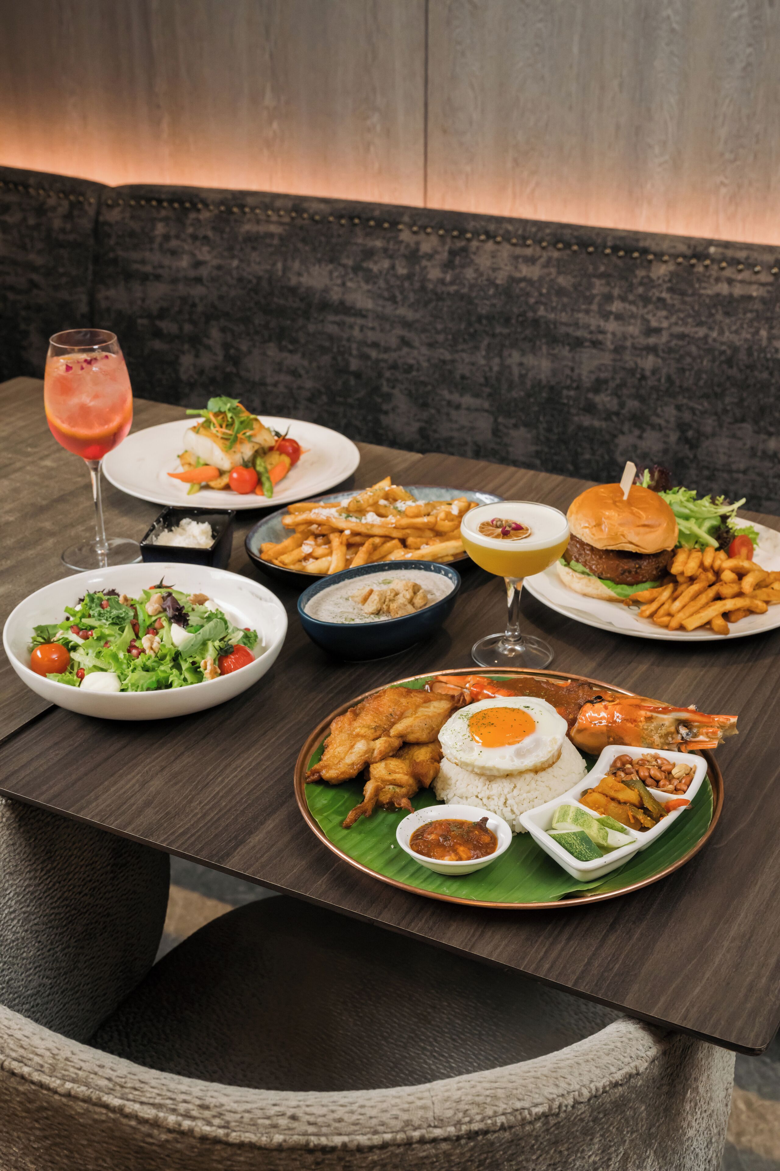 A dining table with various dishes including seafood, fries, and salads.