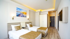 Una habitación de hotel con dos camas, un cuadro en la pared y un televisor montado.