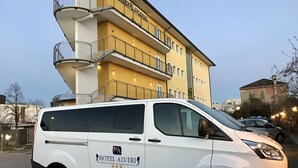 A white van parked in front of a yellow building with balconies, labeled "HOTEL ALVERI." - Hotel Alverì (Mestre)