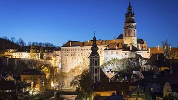 A historic town with a prominent tower and a well-lit bridge.