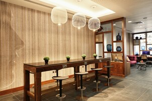 Eine moderne Bar mit Holzboden, Barhocker und hängenden Pendelleuchten.