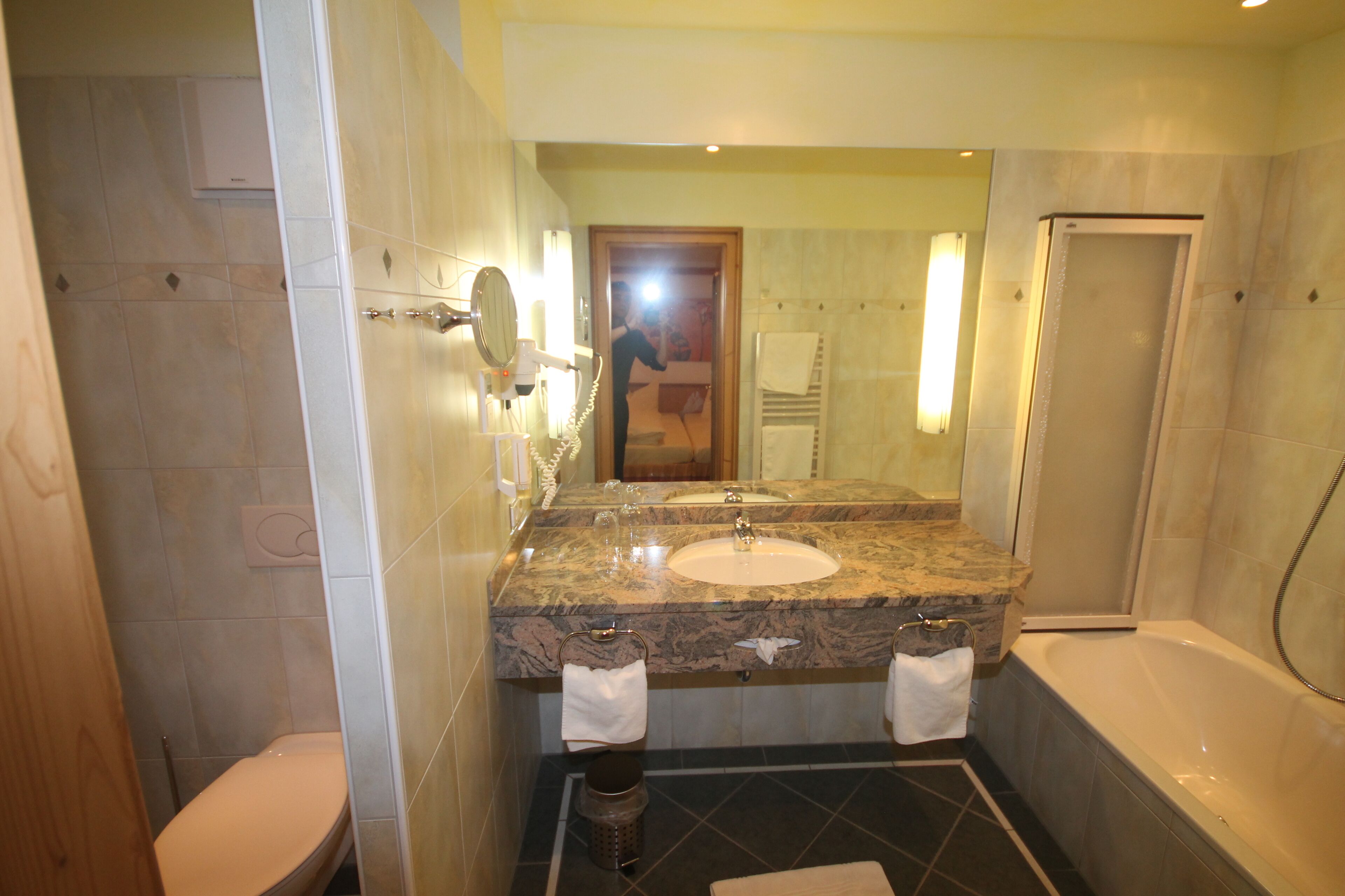 A bathroom with a marble sink, a bathtub, and a shower.