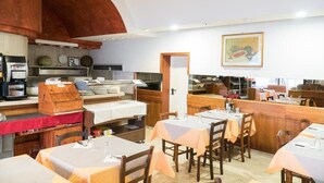 A restaurant with a rustic interior, featuring wooden tables and chairs, a bar area, and a large arched ceiling. - Primavera Hotel (Mestre)