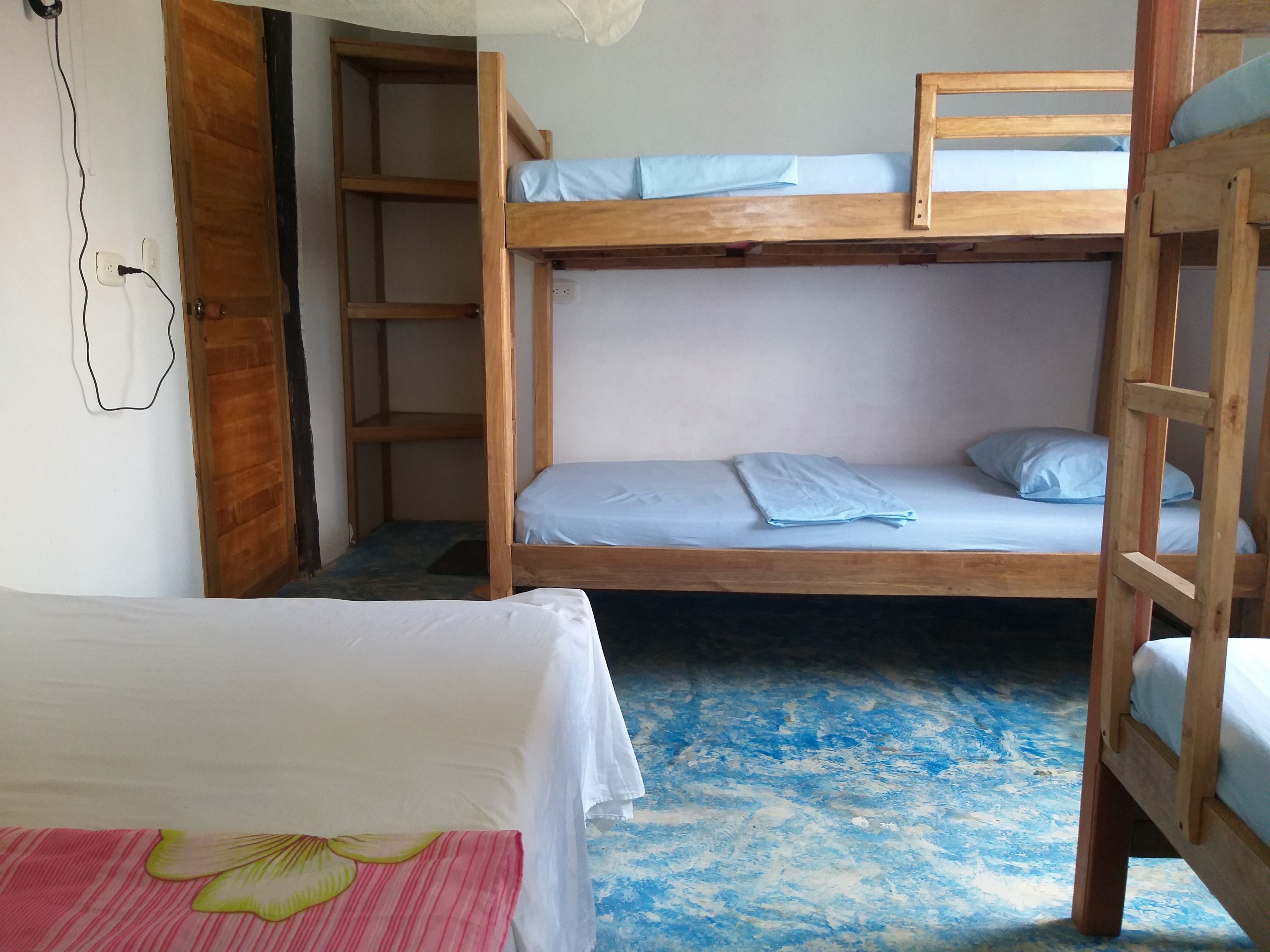 A bunk bed room with a wooden ladder, a desk, and a chair.